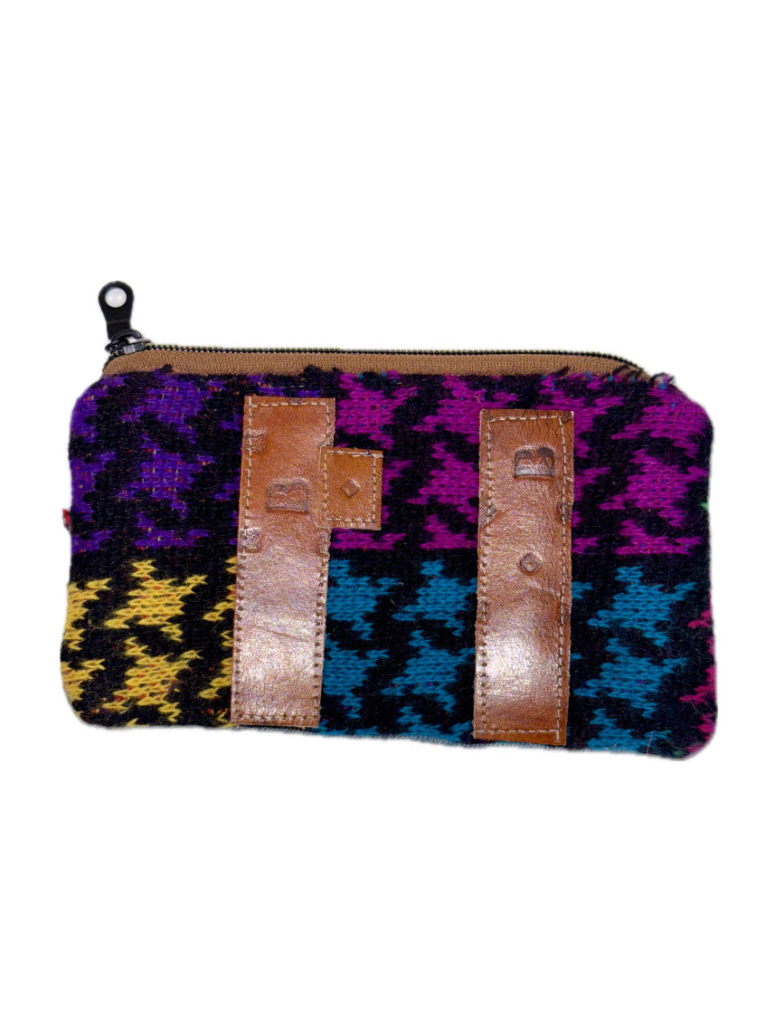 Multicolored patterned pouch with brown leather straps on a white background